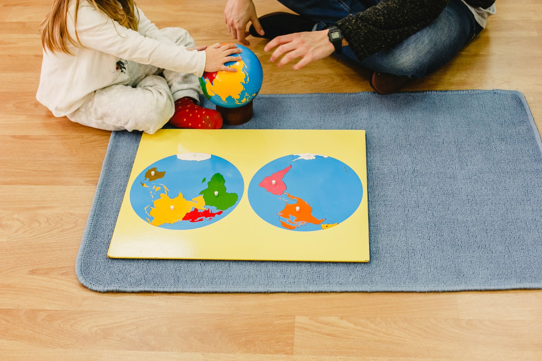 NIña aprendiendo geografía con material montessori de educación cósmica