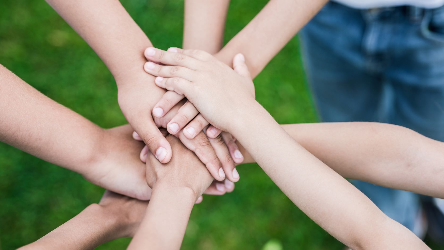 Niños apoyando su manos, en signo de colaboración pacifica