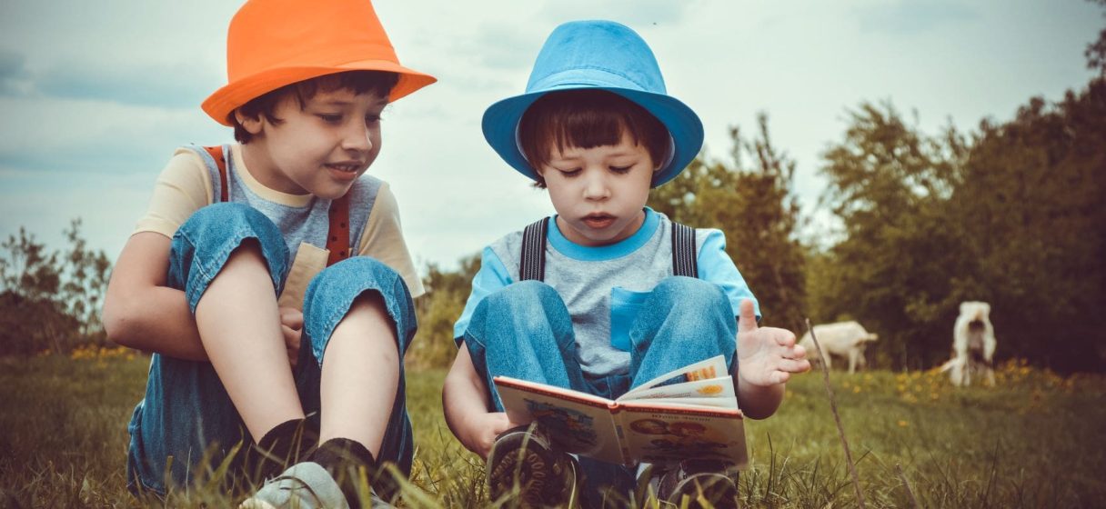 kids-sitting-on-green-grass-field-1094072-min