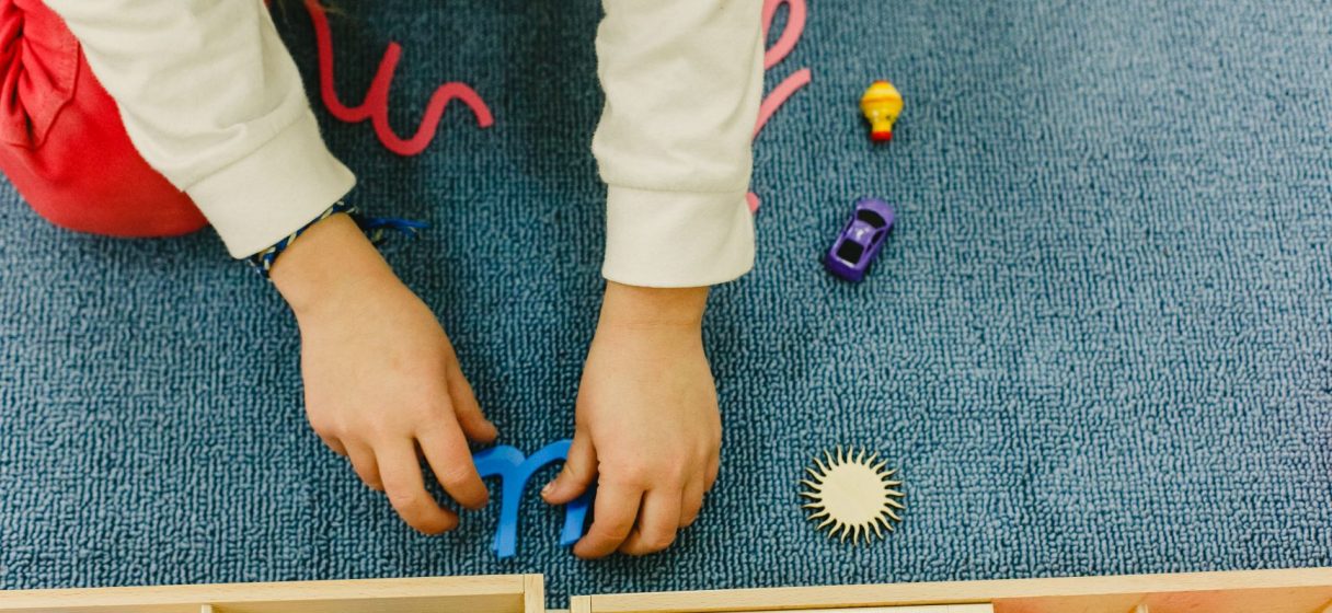 niña usando materiales para trabajar el área del lenguaje con montessori