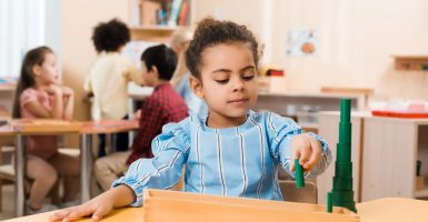 niña utilizando materiales Montessori o los incorrectamente llamados juguetes montessori