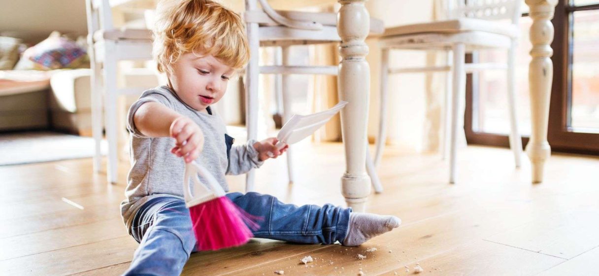 niño manifestando la tendecia humana del trabajo al barrer el suelo