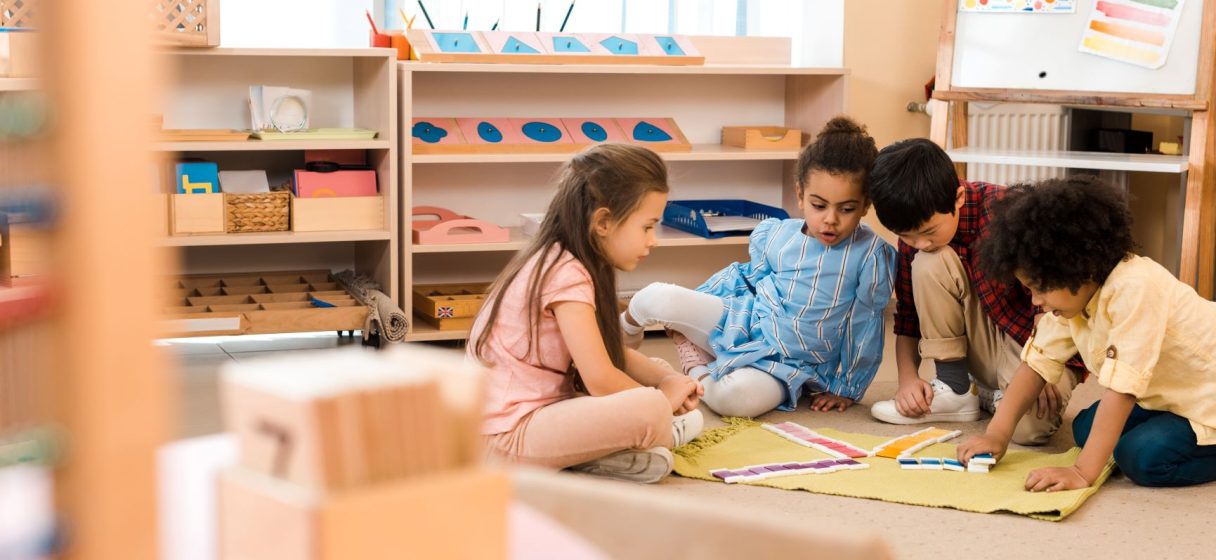 niños en ambiente preparado bajo la observación del asistente montessori