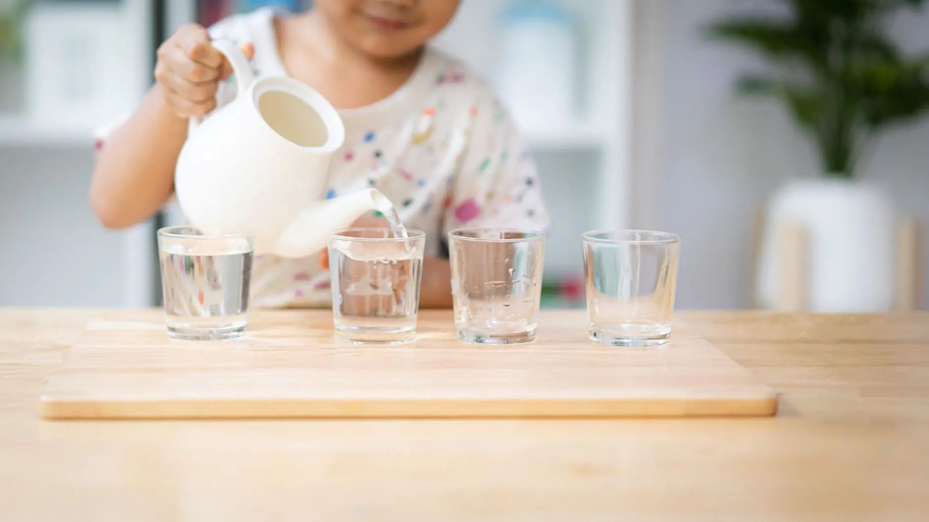 niño echando agua a la hora de comer en el ambiente montessori