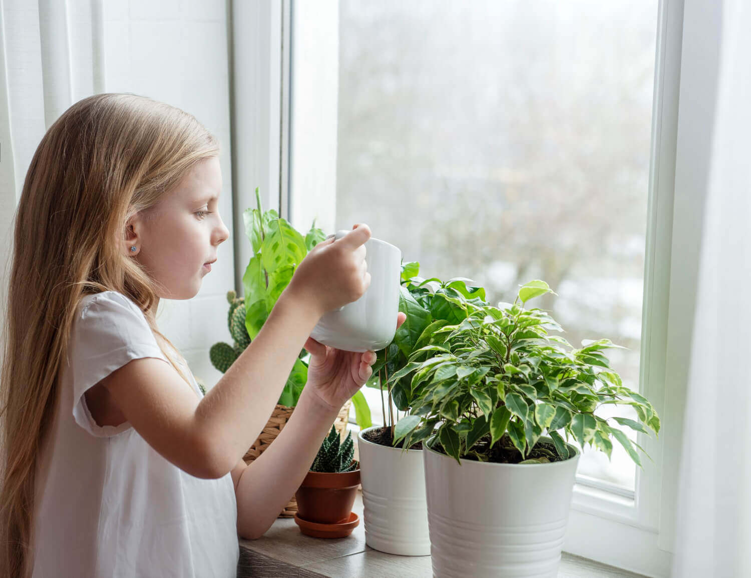 niña regando planta como parte del aprendizaje de vida practica montessori