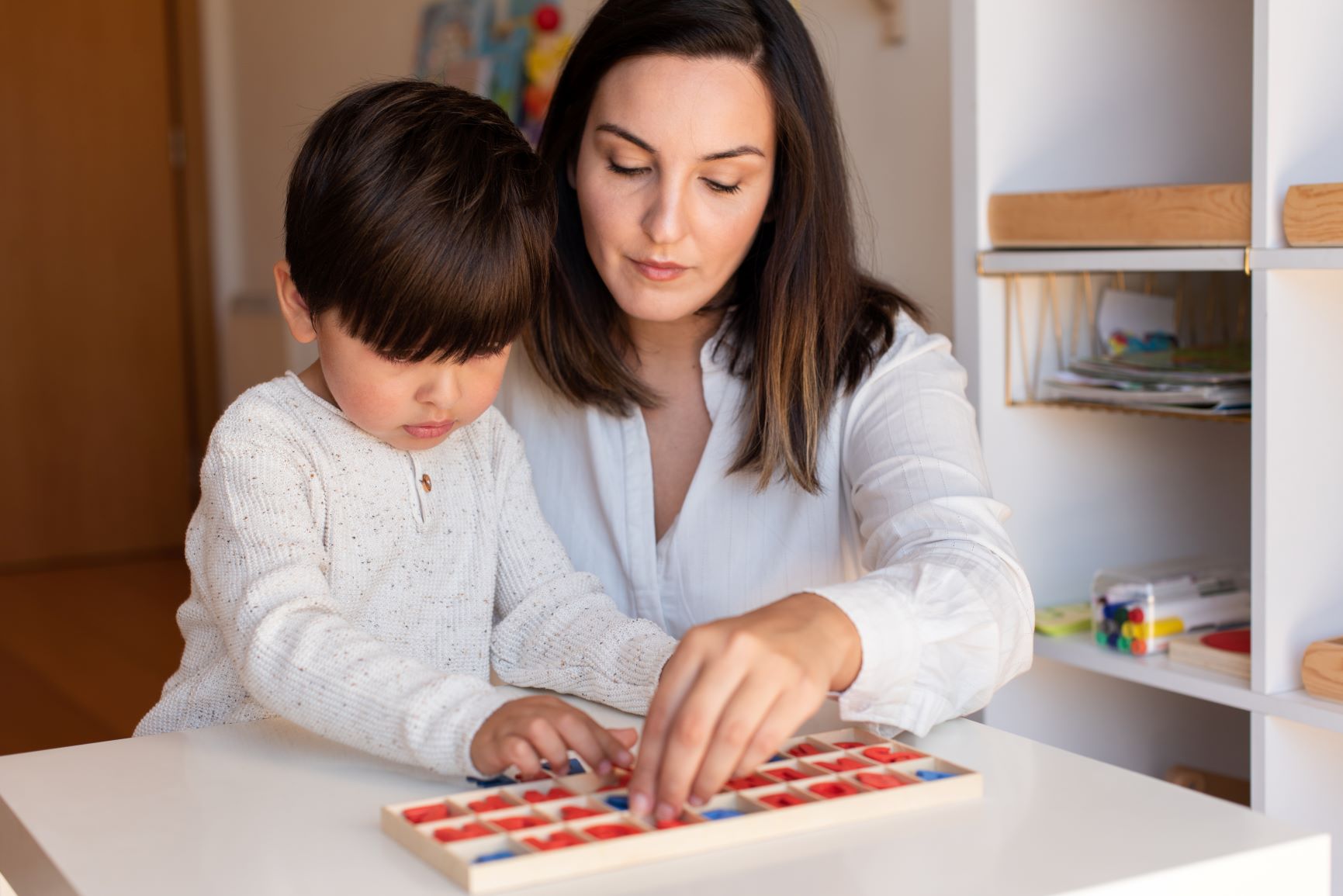 madre mostrando a su hijo el material montessori de matematicas